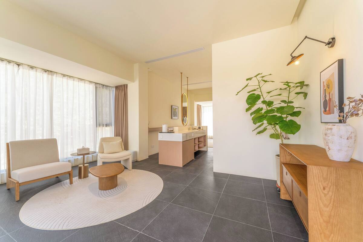 Una sala de estar moderna con sofá, mesa de centro y comedor, con una cocina al fondo.