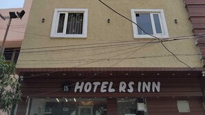 A multi-story hotel with a beige facade and multiple windows. The hotel's name, "HOTEL RS INN," is displayed prominently at the ground level. - Hotel RS INN (Amritsar)