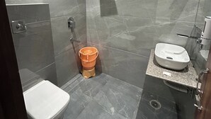 A modern bathroom with a toilet, bidet, and sink. - Hotel RS INN (Amritsar)