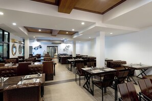A restaurant with multiple dining areas, including booths and tables, with a modern interior design and a visible entrance in the background. - Arawana Express North Pattaya (Pattaya)