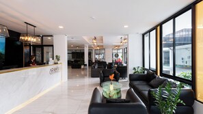 A modern hotel lobby with a reception desk, seating area, and large windows offering views of the city. - Arawana Express North Pattaya (Pattaya)