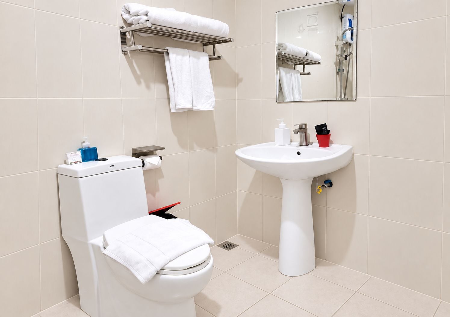 A modern bathroom with a toilet, sink, and towel rack.