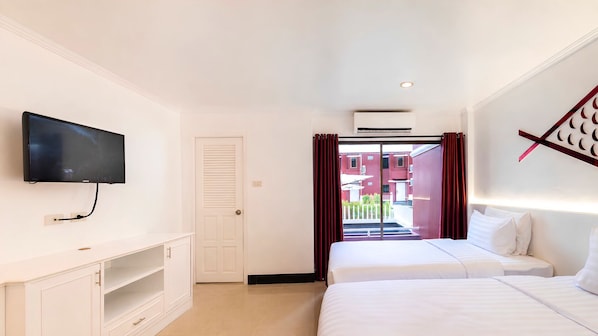 Een hotelkamer met een bed, een aan de muur bevestigde televisie, een deur en een airconditioner.