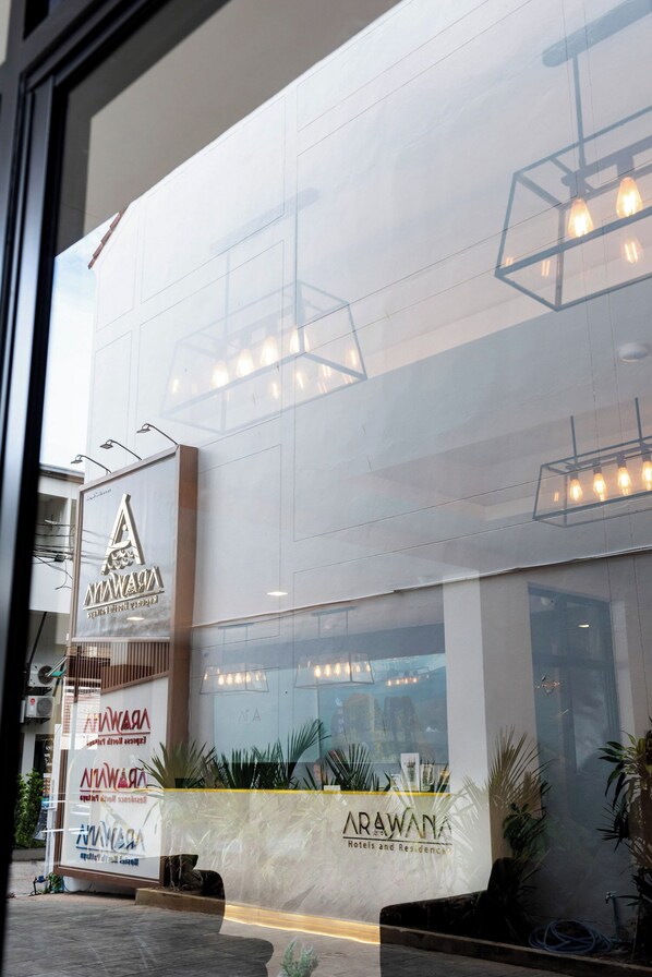 Eine moderne Hotelansicht mit einem gut sichtbaren Logo und Schildern für 'Arawana Hotels and Residences'.