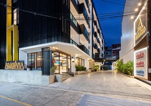 A modern hotel entrance with a glass facade, outdoor seating, and a well-lit pathway leading to the entrance. - Arawana Express North Pattaya (Pattaya)
