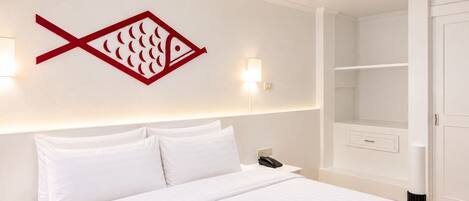 Een hotelkamer met een bed, een wandlamp, een telefoon en een kledingkast.