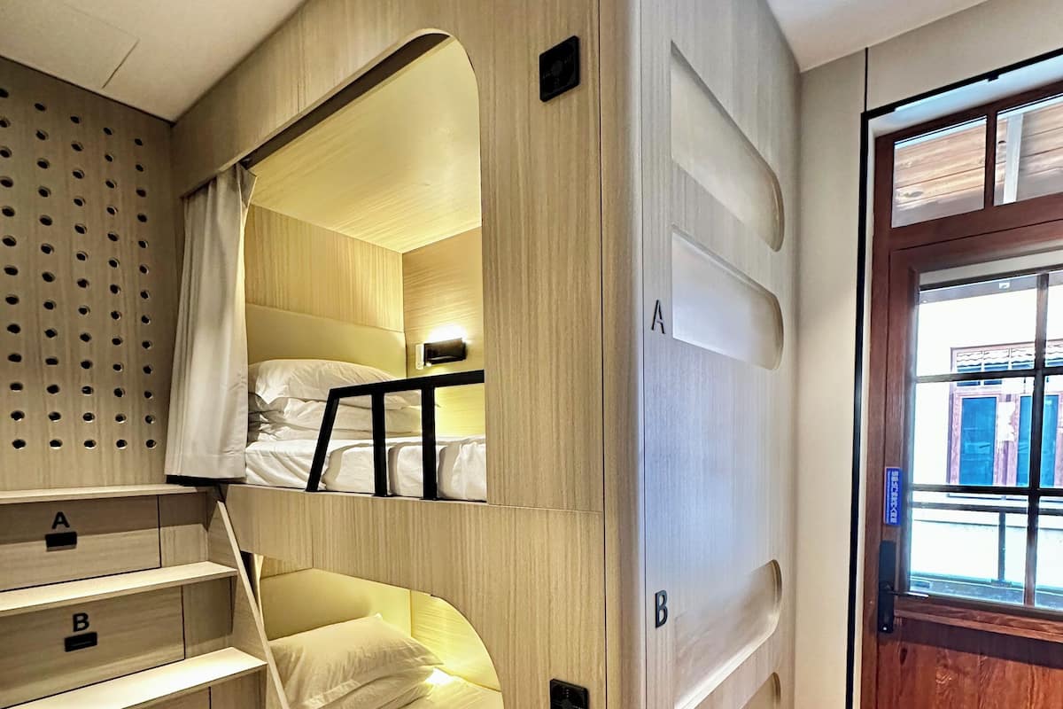 A bunk bed with a wooden finish and built-in storage drawers labeled A, B, C, and D.