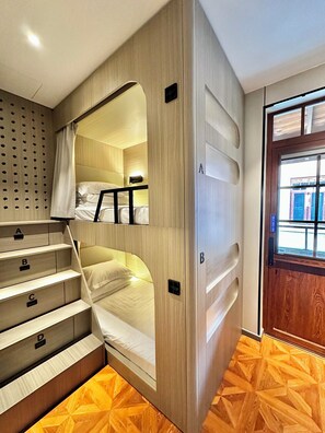 A bunk bed with a wooden finish and built-in storage drawers labeled A, B, C, and D. - Yuanjili International Youth Hostel (Qingdao)