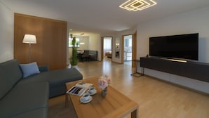 A modern living room with a sofa, coffee table, and a flat-screen TV.