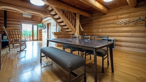 A wooden interior with a dining table, benches, and a staircase. - LAKE TOYA MOON HILLS (Toyako)