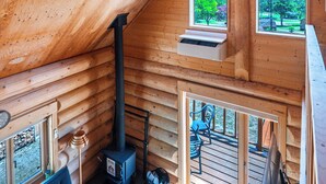 A log cabin interior with a sofa, a bench, a TV, and a fireplace. - LAKE TOYA MOON HILLS (Toyako)