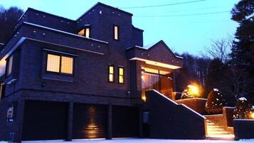 A modern two-story house with a brick exterior, large windows, and a garage.