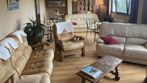 A cozy living room with leather sofas, a coffee table, and a bookshelf filled with books. - HOTEL LA GRANGE (Boutx)