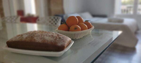 A table with a loaf of bread and a basket of oranges. - Palazzo Caratozzolo (Agrigento)