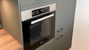 Una cocina equipada con horno empotrado, microondas y refrigerador.