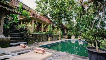 A pool area with lounge chairs and a staircase leading to a building.