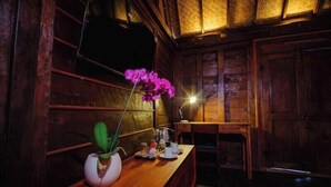 Un interior de madera con mostrador de madera, una planta en maceta y una lámpara de mesa.
