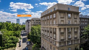 A multi-story building with a classic architectural style, featuring a central courtyard and surrounding greenery. - Apartamenty Sun & Snow Wałowa (Warsaw)