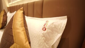 Primer plano de una cama con cabecera y almohadillas.