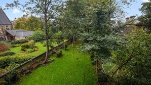 En velholdt have med forskellige planter og en stenvæg.