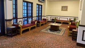 A lobby with a fireplace, seating area, and large windows.