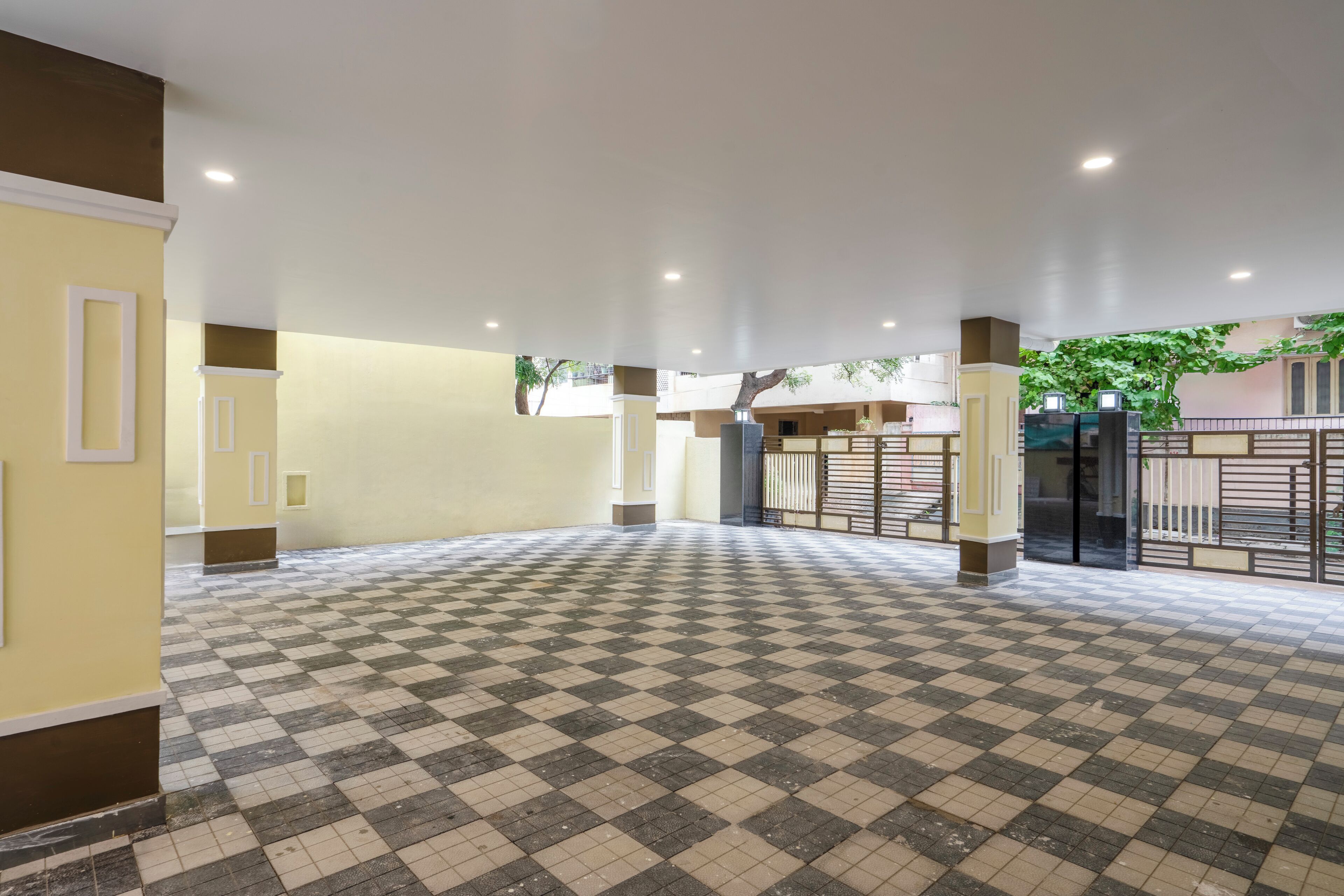 A spacious indoor area with a checkered floor, white walls, and a gated entrance.