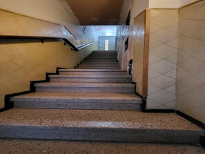 Una scala con corrimano che conduce a una porta in alto.