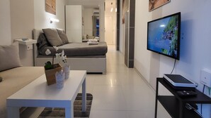 A modern hotel room with a bed, a TV, a desk, and a chair. - Seaside Apartment Las Palmas Near Playa Canteras (Las Palmas de Gran Canaria)