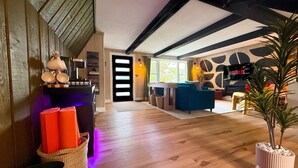 Una sala de estar moderna con piso de madera, un sofá, una mesa de centro y un televisor.