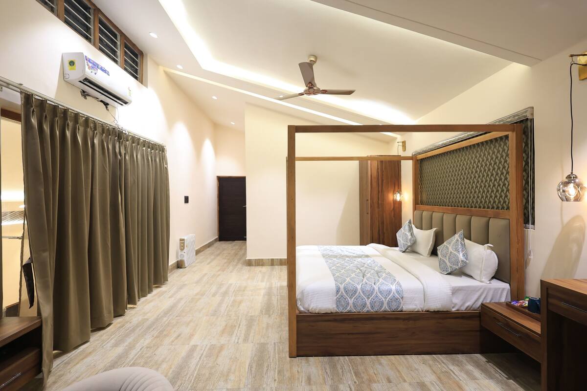 A modern bedroom with a wooden bed, a ceiling fan, and an air conditioning unit.