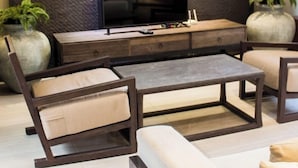 Una sala moderna con un televisor de pantalla plana grande, paneles de pared texturizados oscuros y un diseño minimalista.