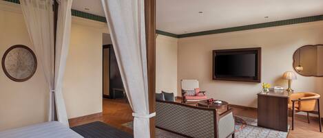 A hotel room with a bed, a desk, a chair, a television, and a window with curtains.