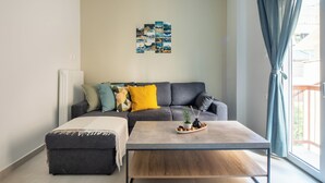 A modern living room with a grey sofa, a wooden coffee table, and a wall art piece. - Theai 1-Bedroom Apartment in Athens (Athens)