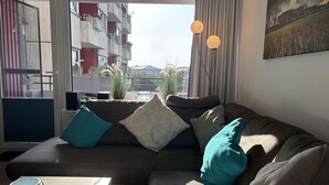 Una sala moderna con un sofá modular, una mesita y una planta en maceta.