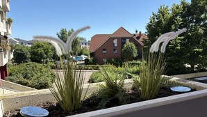 Un jardín en la azotea con plantas y una tapa de alcantarilla.