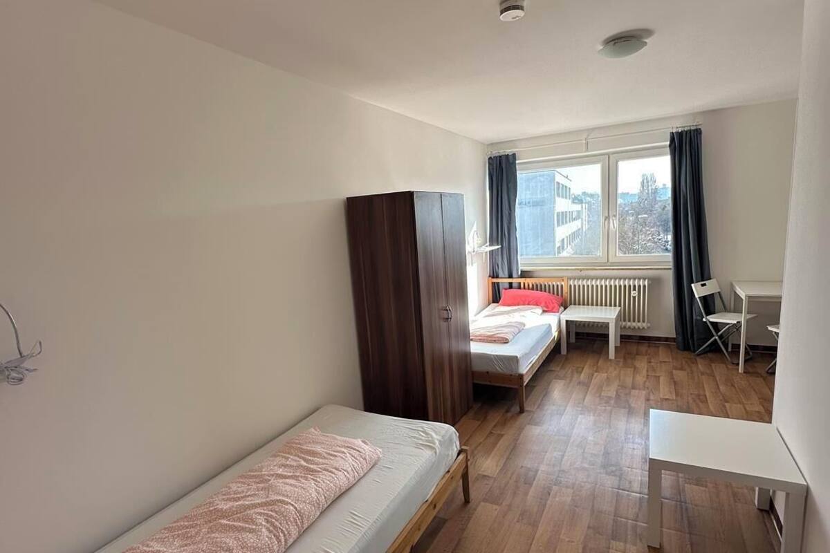 Una habitación con una cama individual, un escritorio y un radiador.
