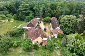 Vista aérea de una zona residencial con casas, un sendero de tierra y follaje circundante.