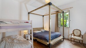 A room with a four-poster bed, a bunk bed, a chair, and a window with a view of greenery. - Domaine de La Contie – 17th-Century Chartreuse in the Heart of 20 Hectares of Nature (Issac)