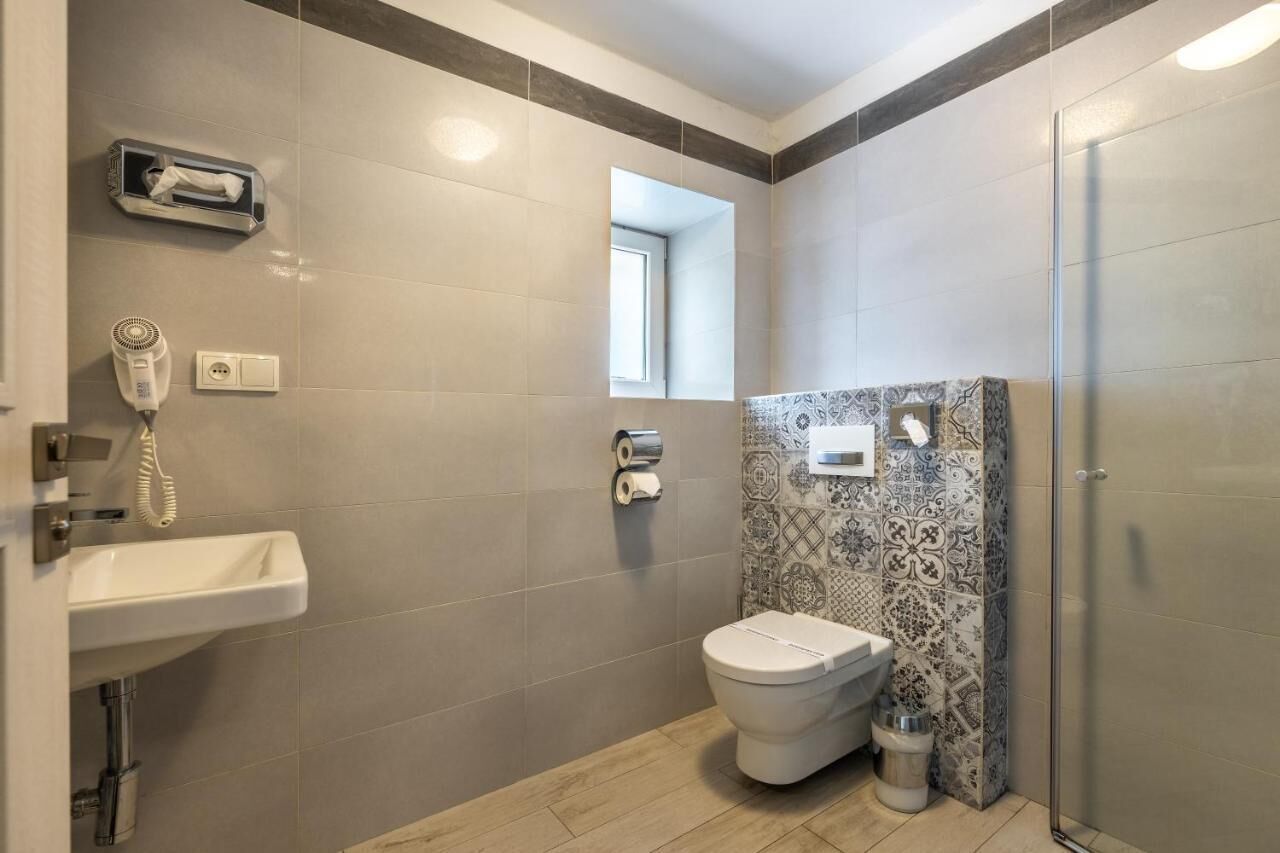 A modern bathroom with a sink, toilet, and shower.
