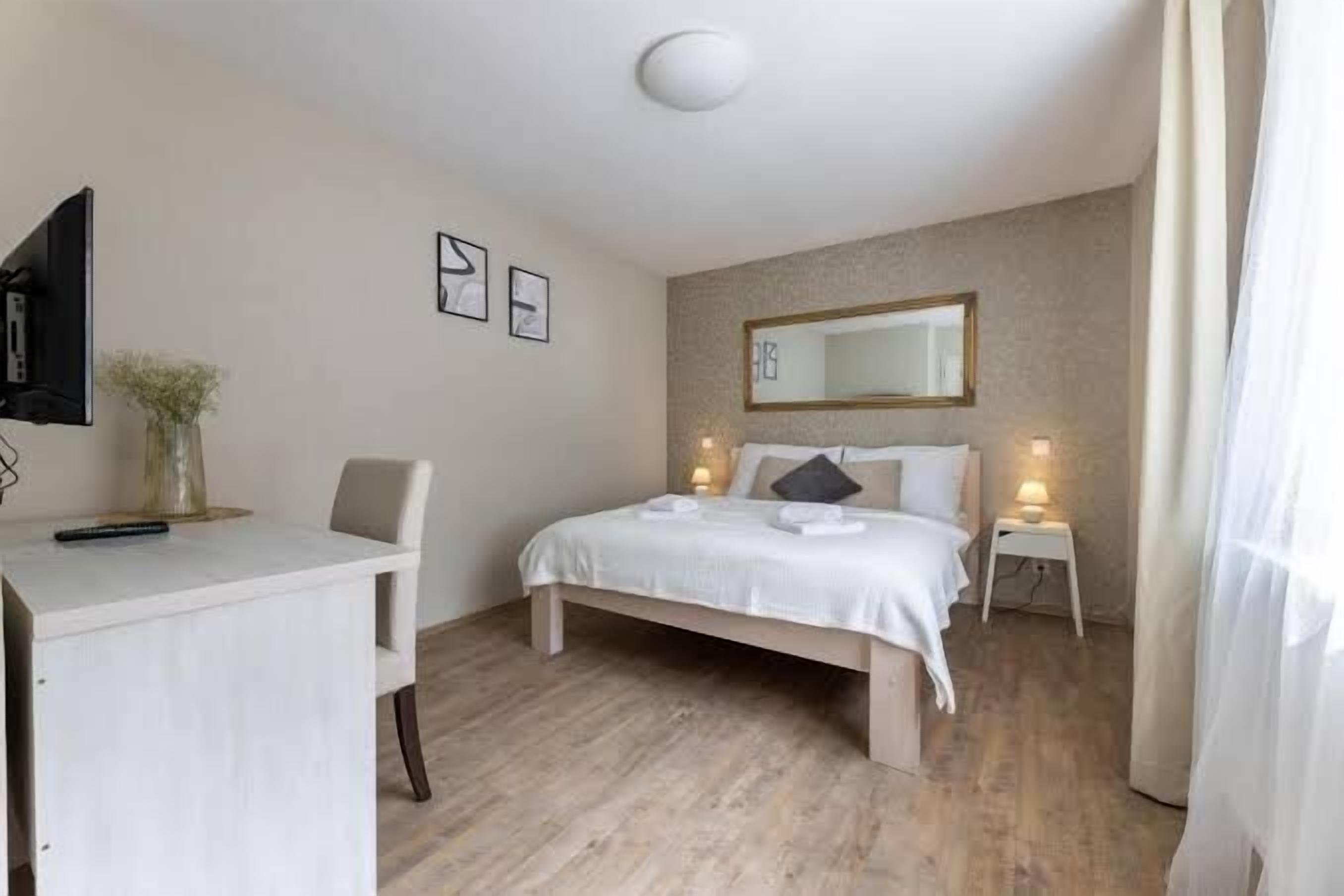 Ein Schlafzimmer mit einem Bett, Nachttischen, einem Schreibtisch und einem Stuhl.