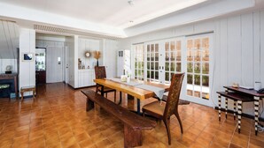 Een ruime keuken met een houten tafel en stoelen, een ingebouwde oven en een groot raam met uitzicht op de omgeving.