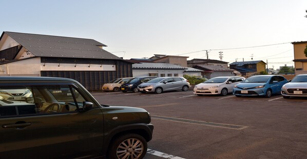 A parking lot with several cars and buildings in the background. - Hotel Pearl City Akita Kawabata (Akita)