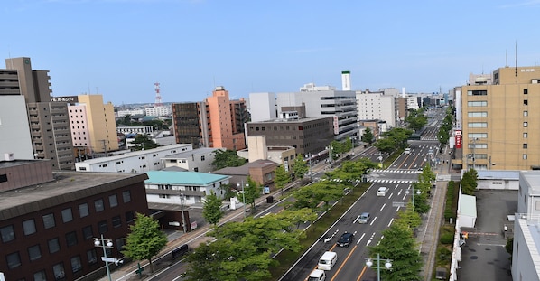 A cityscape with a wide road, buildings, and a clear sky. - Hotel Pearl City Akita Kawabata (Akita)