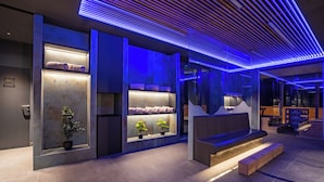 Ein modernes Interieur mit einer Rezeption, einer Sitzecke und einer Treppe.