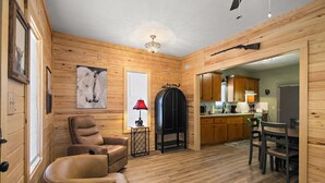 Un interno in legno con zona living, un tavolo da pranzo e una cucina.