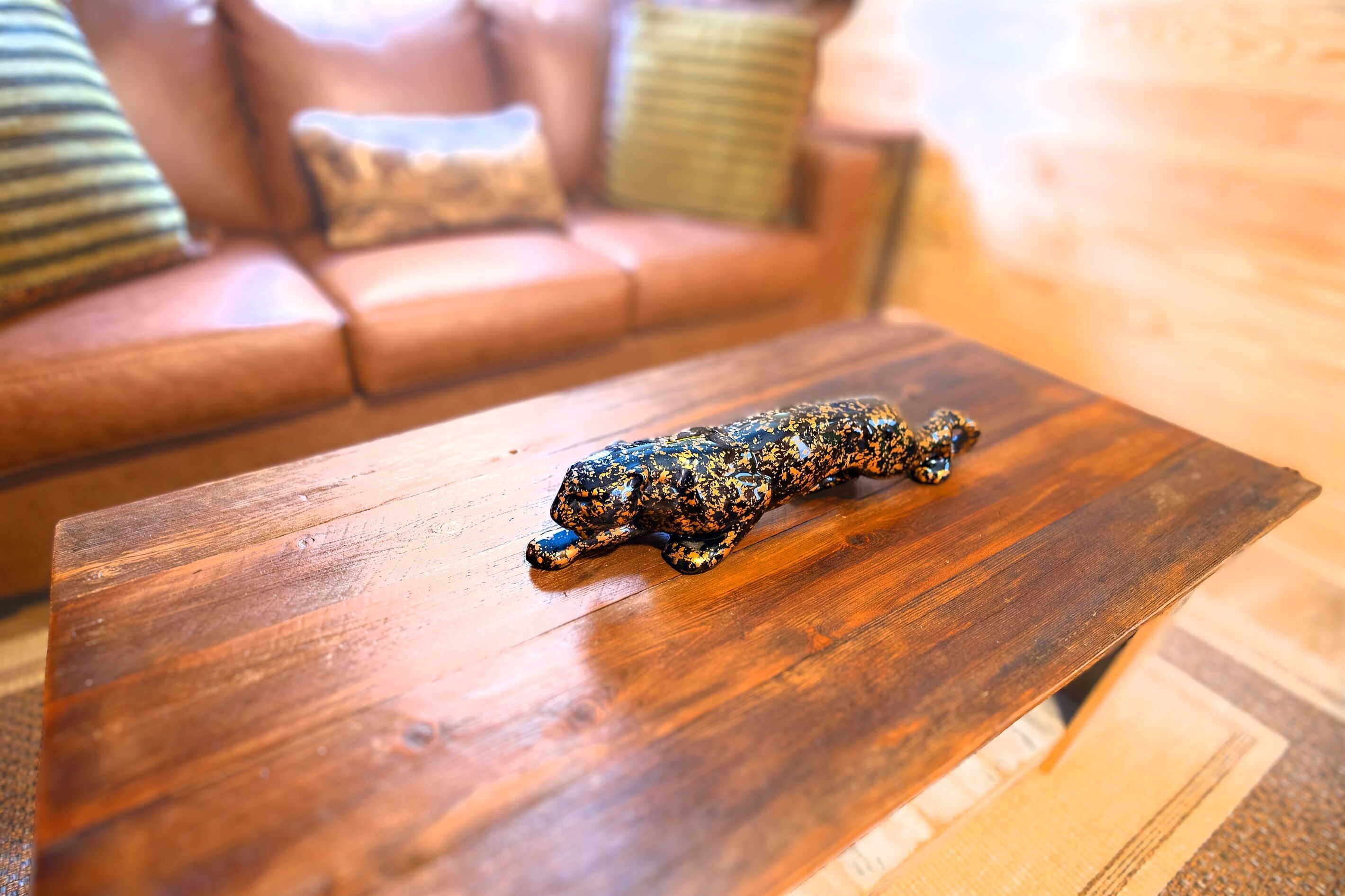 Una mesa de centro de madera con una figurita de leopardo.
