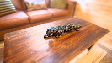 Una mesa de centro de madera con una figurita de leopardo.
