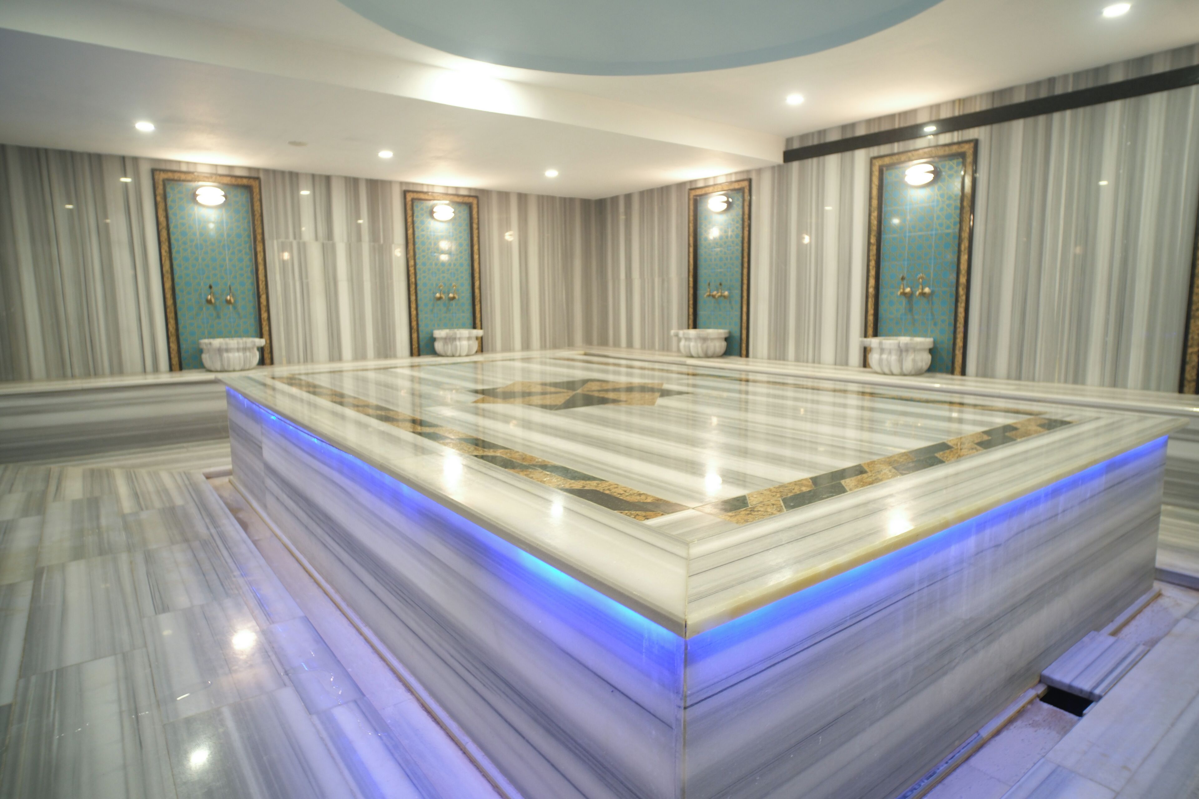 Une salle de bain spacieuse dotée d’un grand meuble-lavabo en marbre, de plusieurs vasques et d’un design moderne.