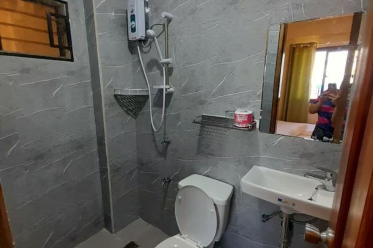 A bathroom with a toilet, shower, and sink.