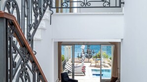 A modern interior with a staircase, a seating area with a view of the pool, and a balcony with a railing. - 4-bedroom villa in wonderful Strp, Kotor with WiFi, fitness room (Strp, Kotor)